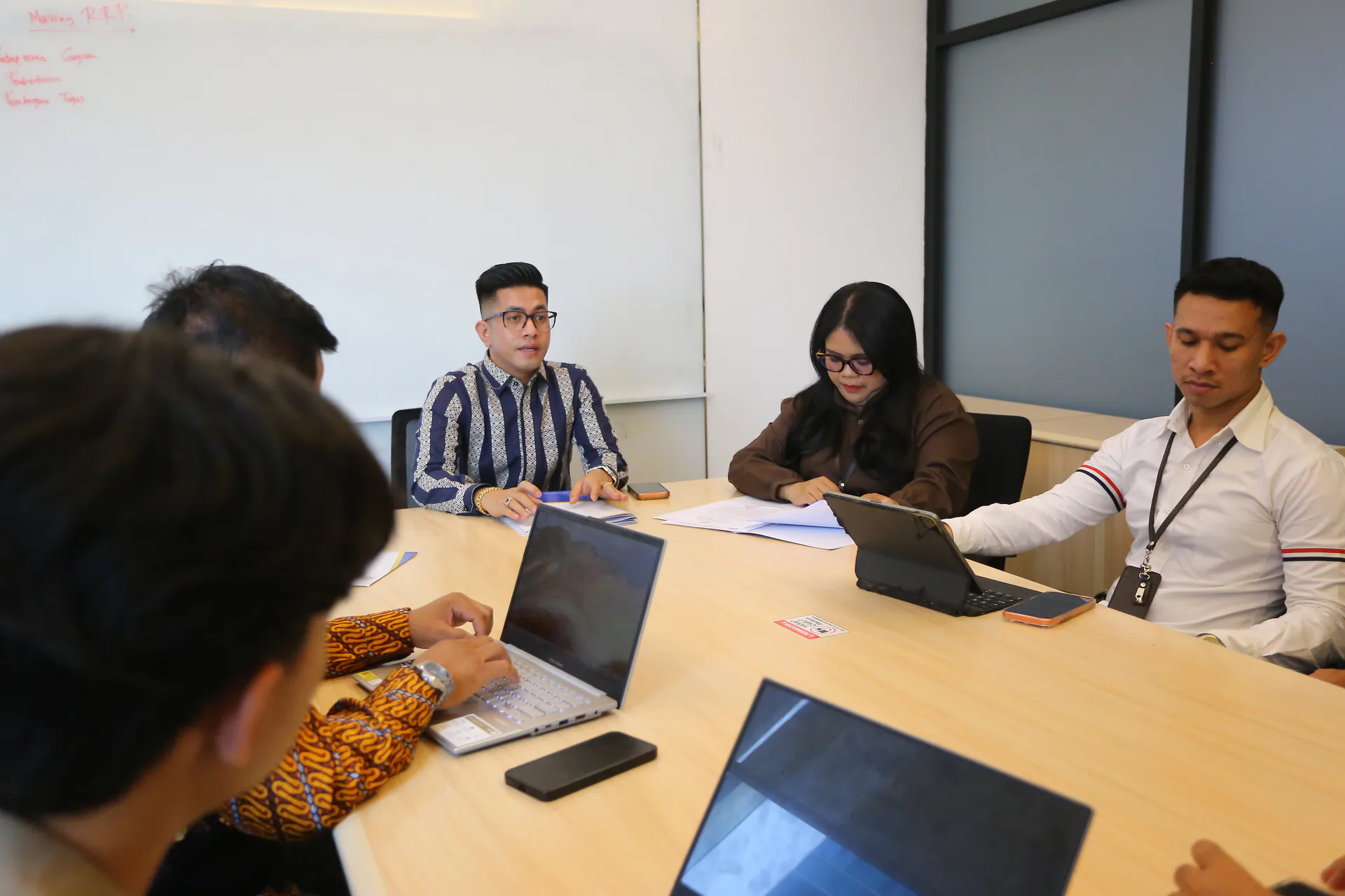 Kolaborasi tim saat menelaah dokumen di ruang rapat